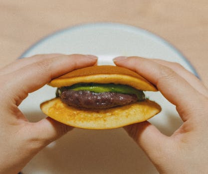 Hands holding a Japanese dorayaki filled with matcha and red bean, typical of Tokyo's culinary delights.