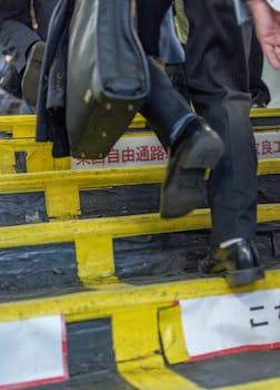 A businessman in formal attire ascends subway stairs in Tokyo, Japan.